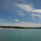 Blick über den See auf den leeren Strand im Strandbad Langener Waldsee