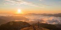 Sonnenaufgang mit Kreuz auf einem Berg