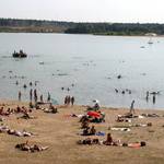 Blick auf den Strand und den See voller Menschen im Strandbad Langener Waldsee
