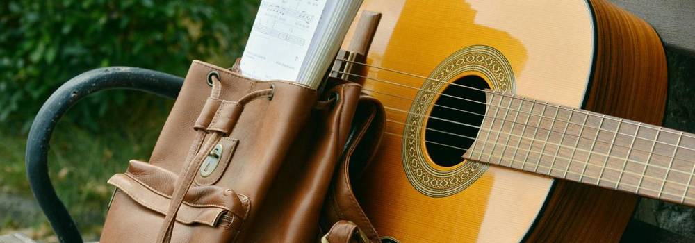 Gitarre und Rucksack auf einer Bank